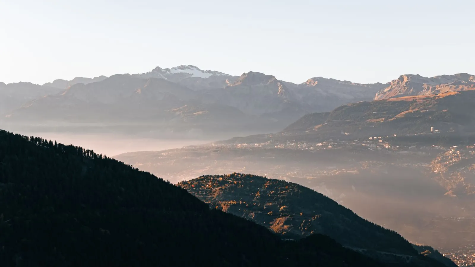 Sommets alpins face à face au-dessus d'une vallée dans la brume - conflits entre associés