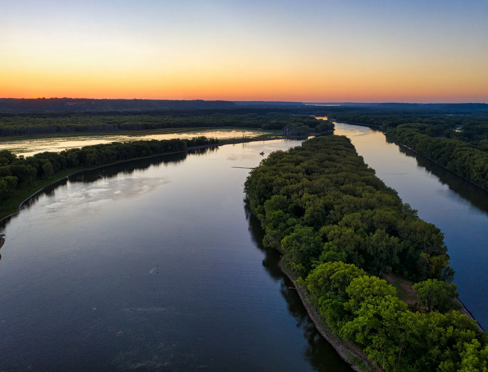 Fleuve dont deux bras se rejoignent après une île, vu du ciel - M&A et cession d'entreprise