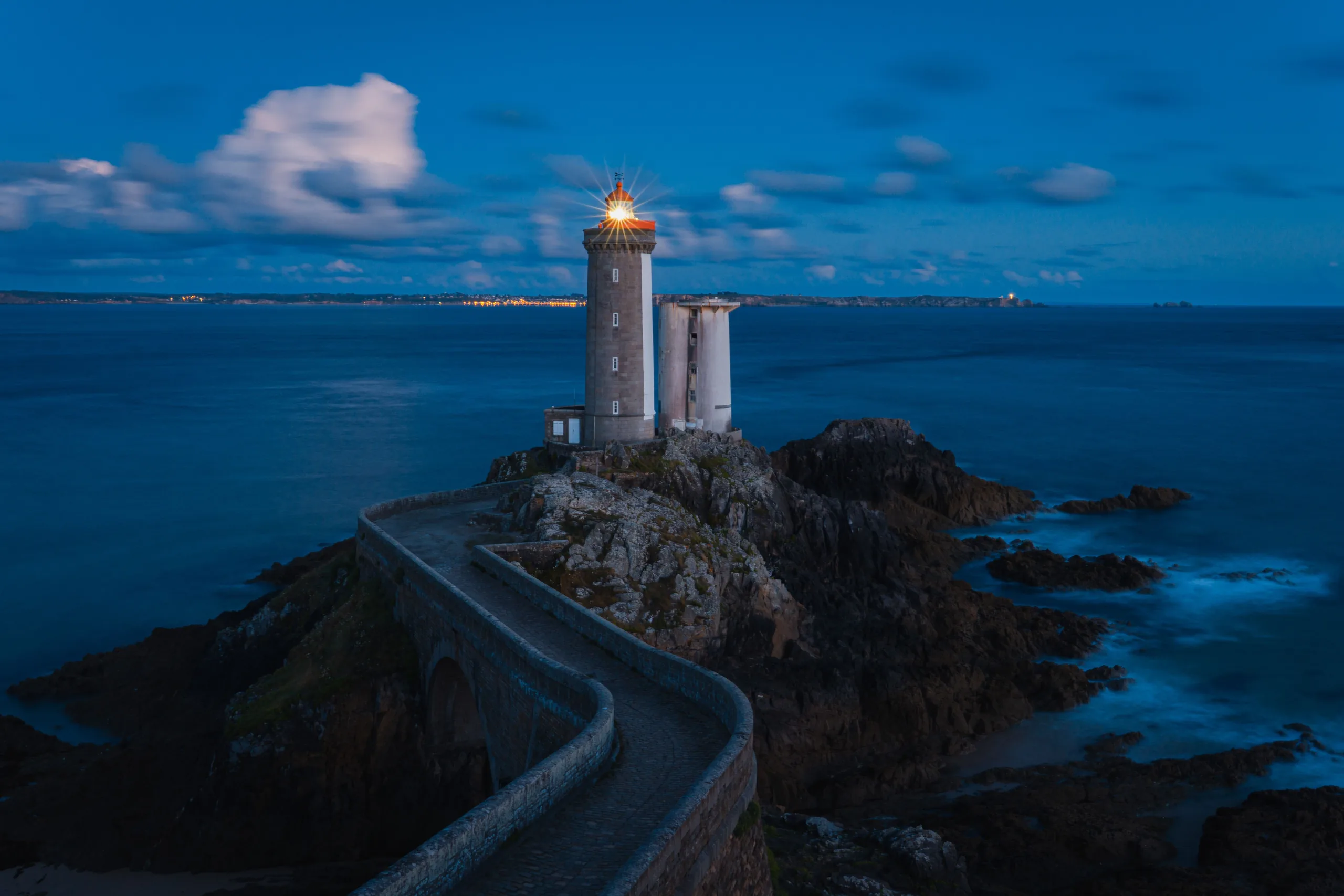 Phare du Petit Minou éclairé à l'heure bleue, au bout de sa jetée de pierre - contentieux commercial et des affaires à Toulon